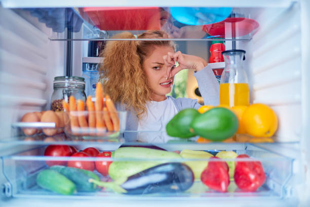 refrigerator odor, a woman pinches her nose